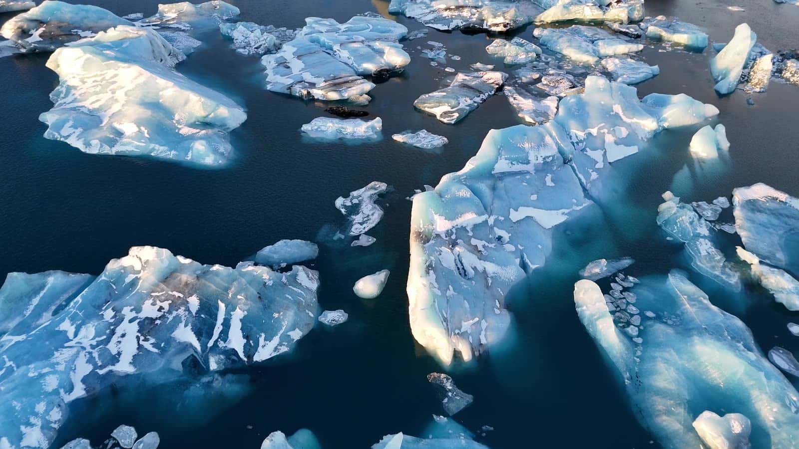 Still water and drifting ice on Jökulsárlón glacier lagoon in soft daylight