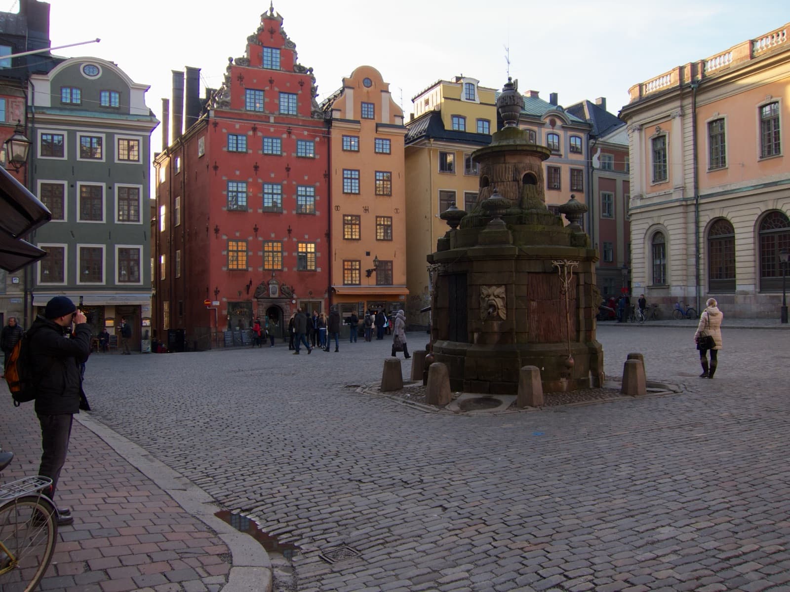 Ochre and red facades around the Stortorget square fountain in Gamla stan, Stockholm
